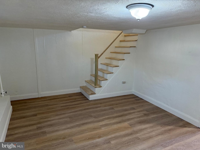 basement with wood-type flooring and a textured ceiling