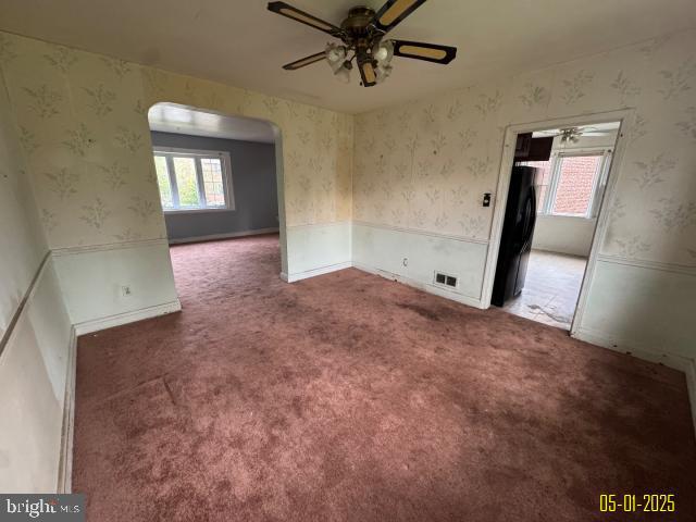 6410 Laurel Dr, Gwynn Oak, MD 21207 - spare room with arched walkways, ceiling fan, healthy amount of natural light, wallpapered walls, and carpet flooring