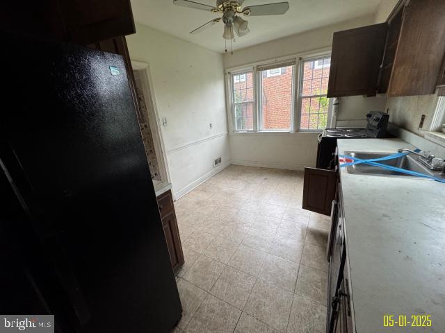 6410 Laurel Dr, Gwynn Oak, MD 21207 - kitchen featuring ceiling fan, black range with electric cooktop, a sink, light countertops, and dark brown cabinets