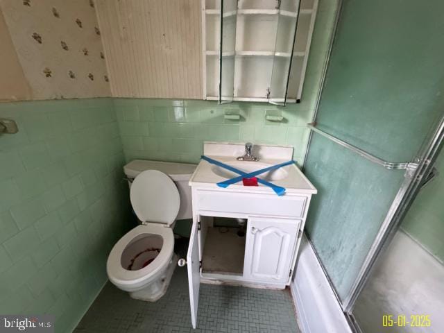 6410 Laurel Dr, Gwynn Oak, MD 21207 - full bathroom with toilet, vanity, tile patterned floors, wainscoting, and tile walls