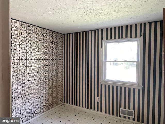 unfurnished room featuring a textured ceiling