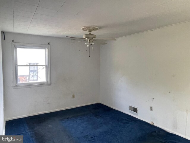 carpeted spare room with ceiling fan