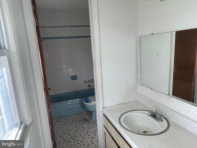 full bathroom featuring toilet, vanity, tile patterned floors, and tiled shower / bath