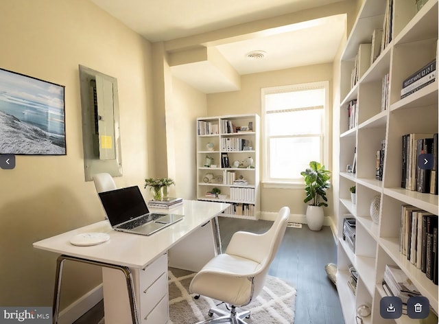 office with wood-type flooring and electric panel