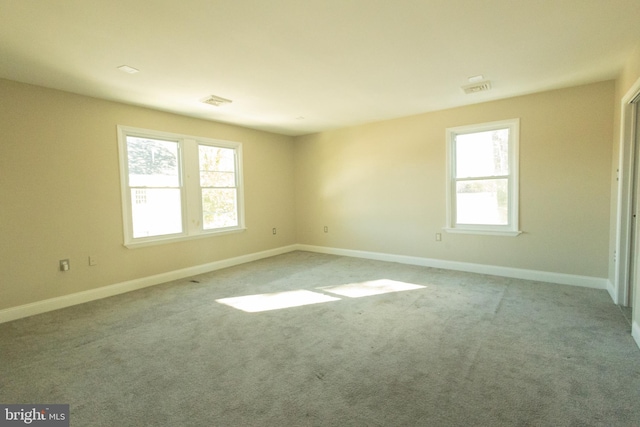 spare room with light colored carpet and plenty of natural light