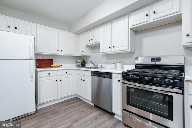 kitchen featuring light wood-type flooring, white cabinetry, sink, and appliances with stainless steel finishes