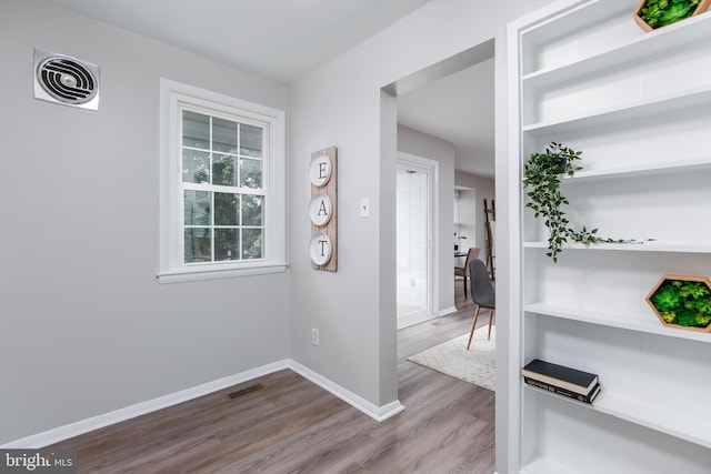 hallway with hardwood / wood-style flooring