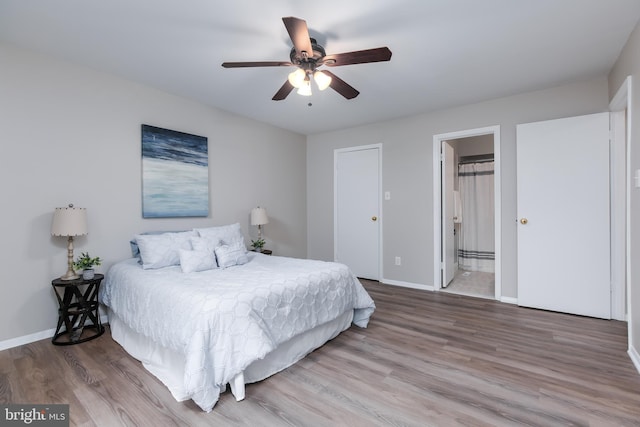 bedroom featuring ensuite bath, ceiling fan, and hardwood / wood-style flooring