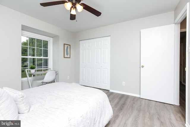 bedroom featuring ceiling fan, light wood-type flooring, and a closet