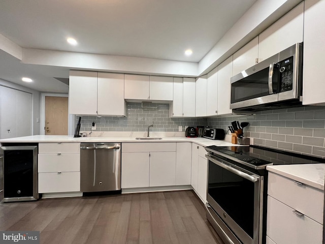 kitchen featuring white cabinetry, sink, dark hardwood / wood-style flooring, and appliances with stainless steel finishes