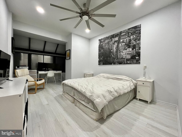 bedroom with ceiling fan, light wood-type flooring, and vaulted ceiling