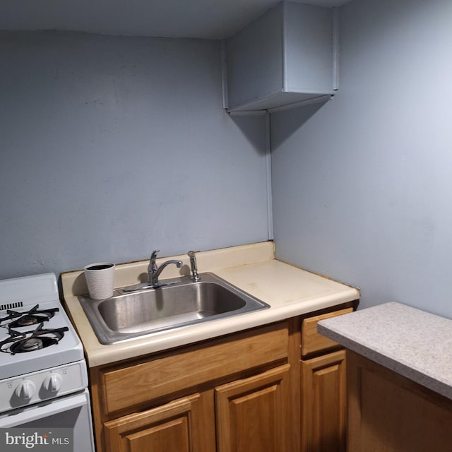 kitchen featuring white gas stove and sink