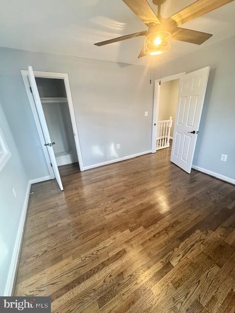 unfurnished bedroom featuring ceiling fan, dark wood-type flooring, and a closet