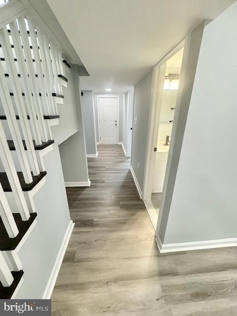 corridor with hardwood / wood-style flooring