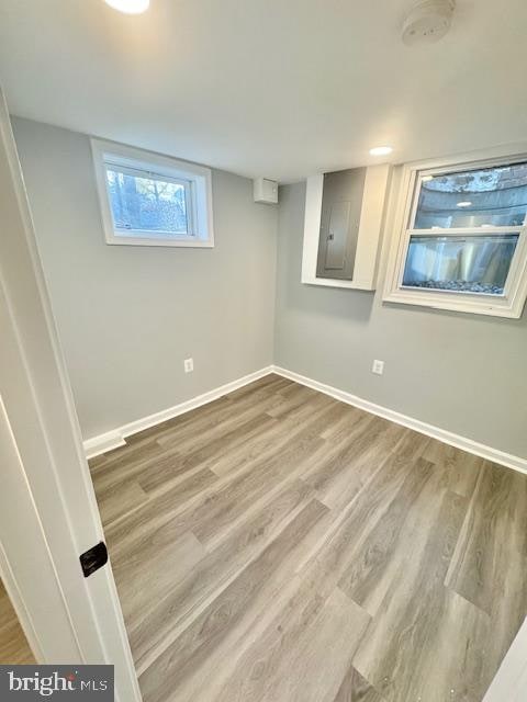 basement featuring wood-type flooring and electric panel