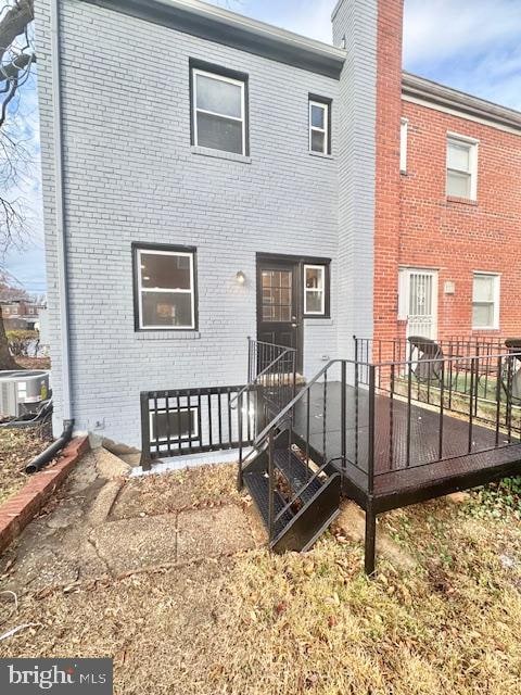 rear view of house featuring a wooden deck and central AC