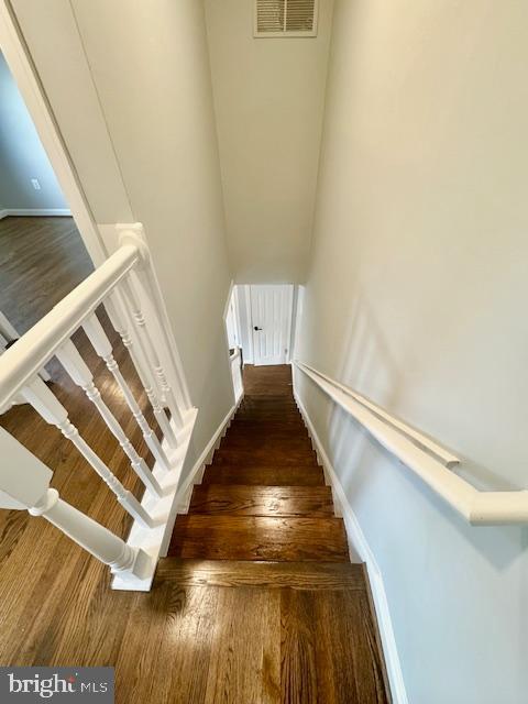 staircase with hardwood / wood-style floors