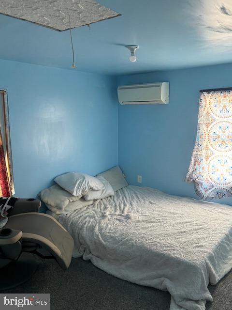 carpeted bedroom featuring a wall mounted air conditioner