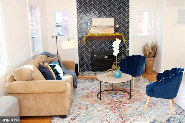 living room with a fireplace, plenty of natural light, and hardwood / wood-style floors