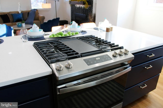 details with light hardwood / wood-style flooring and high end range