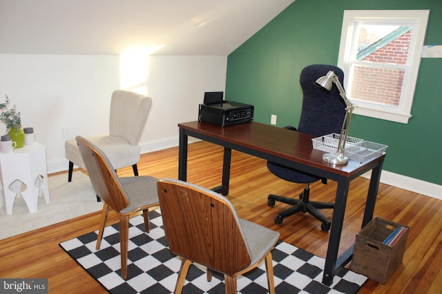 home office featuring hardwood / wood-style flooring and vaulted ceiling