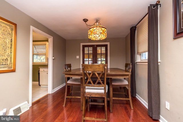 dining space featuring plenty of natural light, dark hardwood / wood-style flooring, and french doors