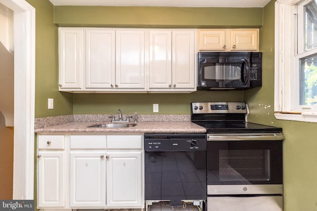 kitchen with black appliances, white cabinets, and sink