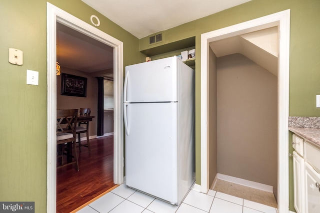 kitchen with white fridge, white cabinetry, and light hardwood / wood-style floors