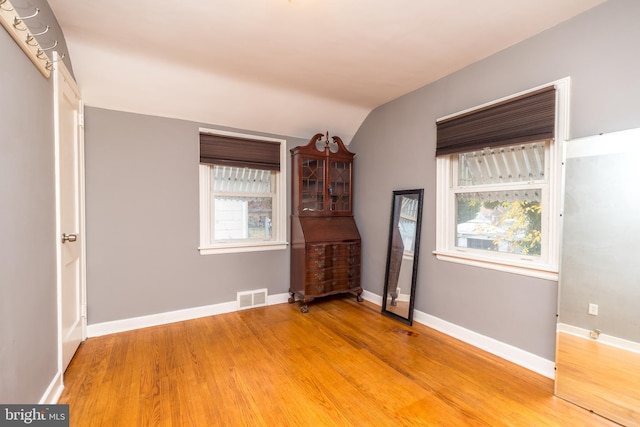 interior space with hardwood / wood-style flooring and vaulted ceiling