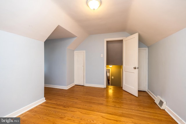 additional living space featuring light hardwood / wood-style flooring and vaulted ceiling