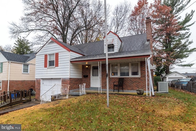 view of front of property with central AC unit, a front yard, and a garage