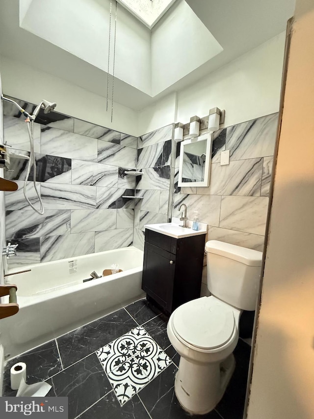 full bathroom with tile patterned floors, vanity, shower / tub combination, tile walls, and toilet