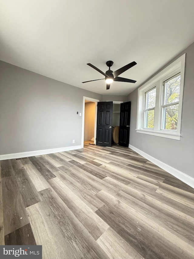 unfurnished bedroom with ceiling fan and light hardwood / wood-style flooring