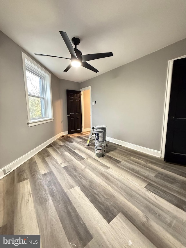 unfurnished bedroom with ceiling fan and wood-type flooring