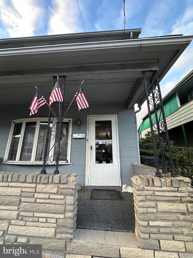 view of exterior entry featuring covered porch