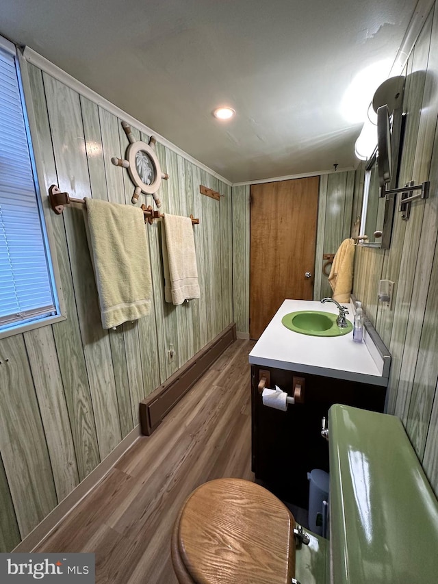 bathroom featuring hardwood / wood-style floors, vanity, toilet, and wooden walls