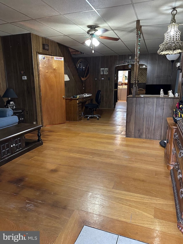 interior space with wooden walls, ceiling fan, and hardwood / wood-style flooring