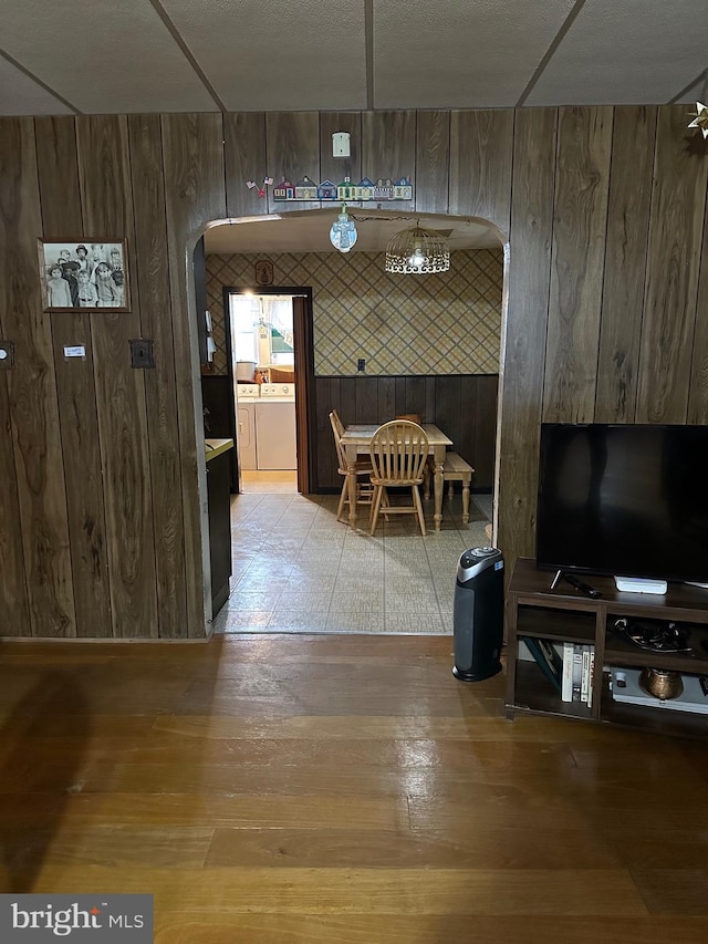 unfurnished dining area with wood walls, hardwood / wood-style floors, and washer and dryer