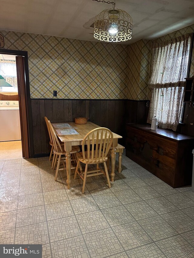 dining room featuring washer / clothes dryer and wood walls