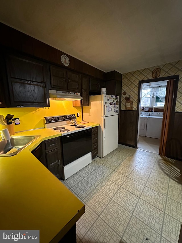 kitchen featuring sink, white appliances, dark brown cabinetry, and washing machine and dryer