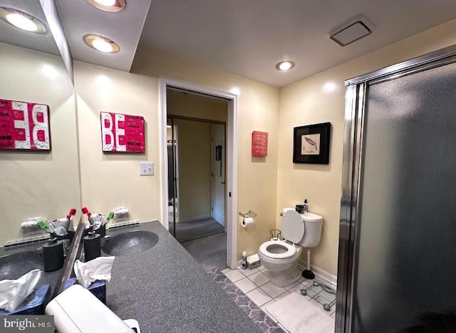 bathroom featuring tile patterned flooring, vanity, toilet, and a shower with door