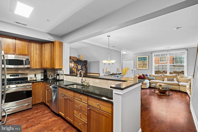 kitchen featuring dark hardwood / wood-style floors, kitchen peninsula, sink, and stainless steel appliances