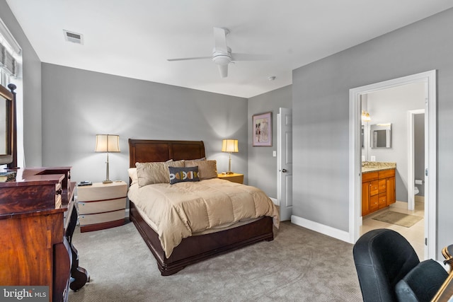 bedroom with ensuite bathroom, ceiling fan, and light colored carpet