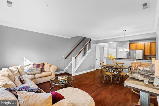 living room featuring a notable chandelier, dark hardwood / wood-style floors, and ornamental molding