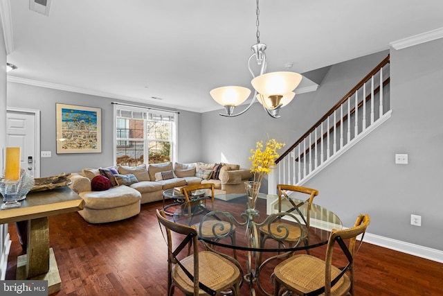 dining room featuring dark hardwood / wood-style floors, crown molding, and an inviting chandelier