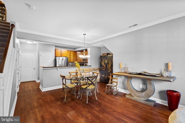 dining area featuring dark hardwood / wood-style floors, ornamental molding, and an inviting chandelier