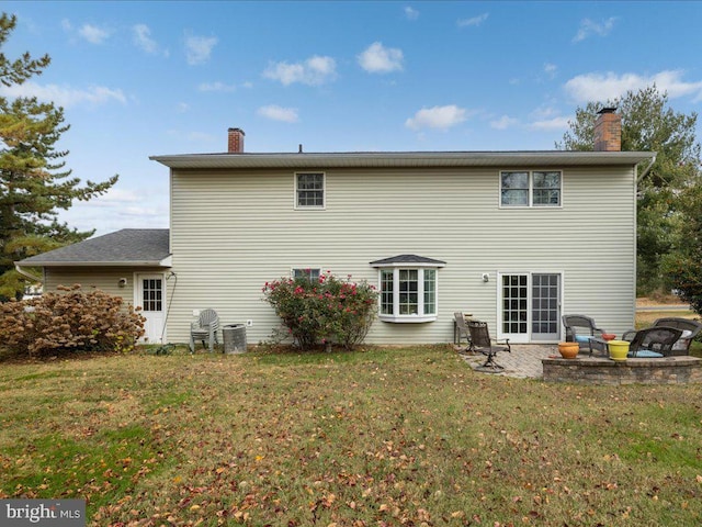 rear view of house with a patio area, a yard, and central AC