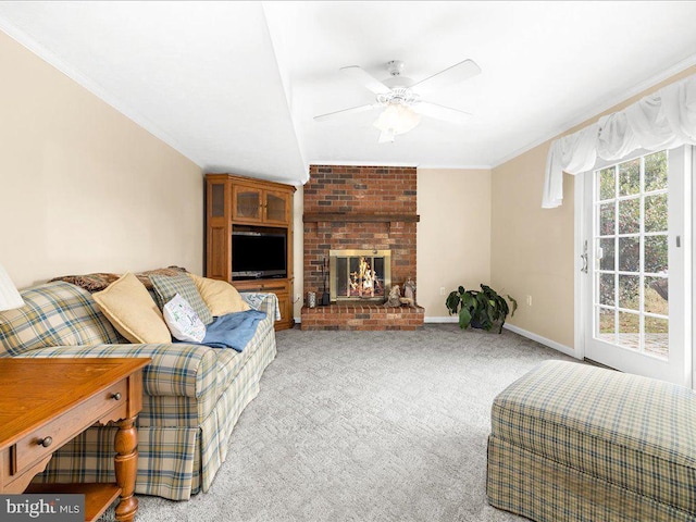 carpeted living room featuring ceiling fan, crown molding, and a brick fireplace