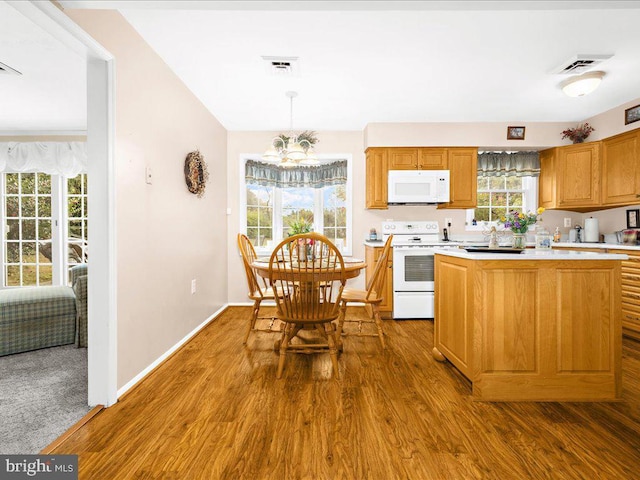 kitchen with hanging light fixtures, a kitchen island, electric range oven, wood-type flooring, and a chandelier