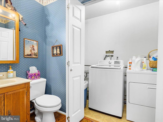 bathroom featuring vanity, washer and dryer, and toilet